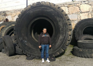 personne se tenant devant un pneu génie civil